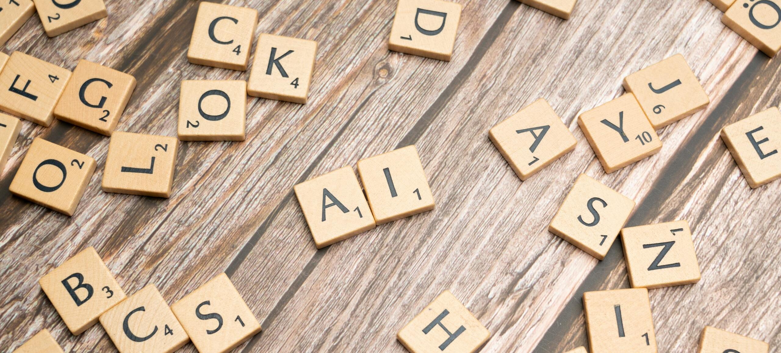 Holzbuchstaben, die auf einer strukturierten Oberfläche verstreut sind und das Wort „AI“ als Abbild für KI-Content im Einheitsbrei bilden.