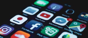 Detaillierte Nahaufnahme eines Smartphone-Bildschirms, auf dem verschiedene Symbole beliebter Social Media-Apps zu sehen sind.